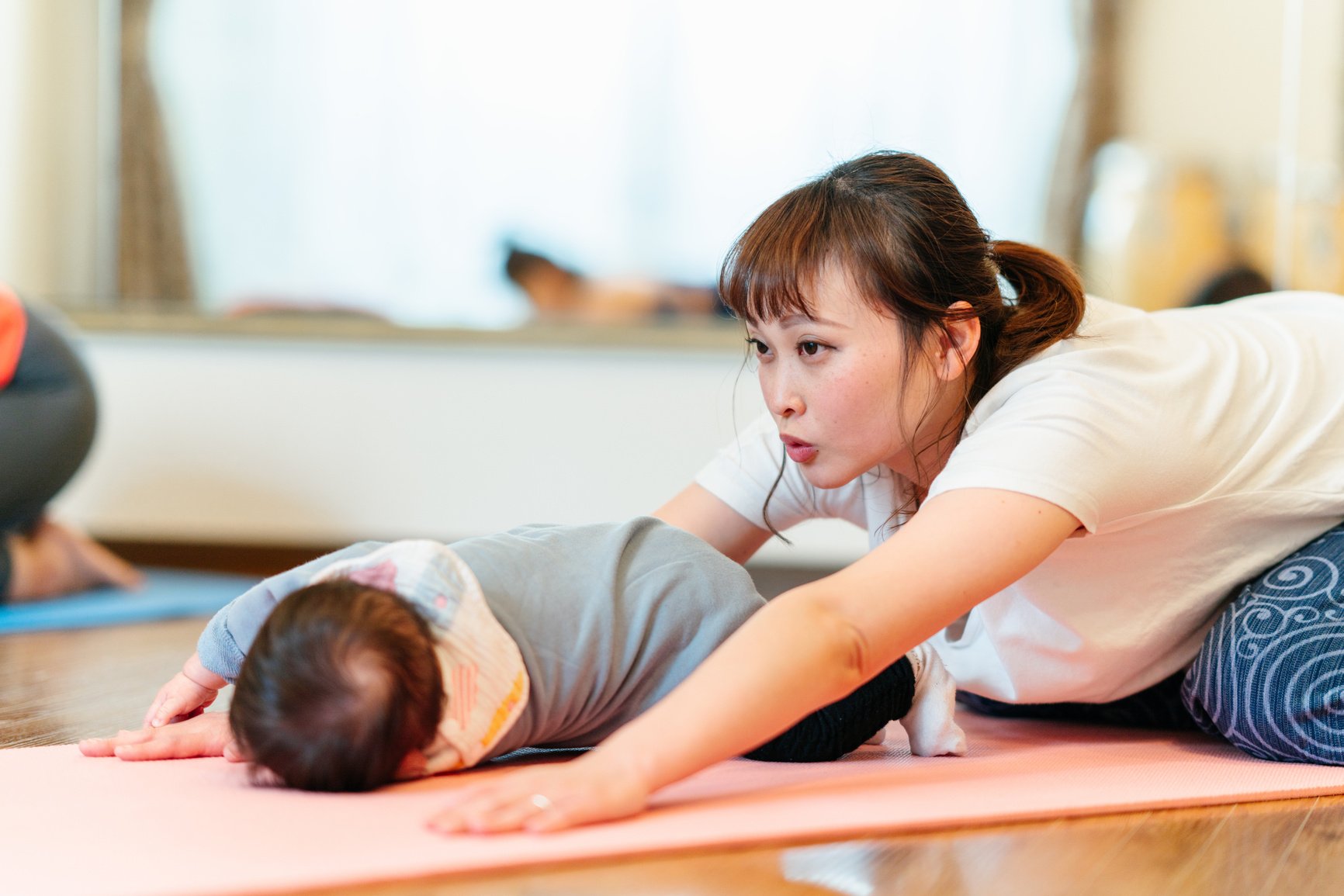 Mother with her baby joining yoga class